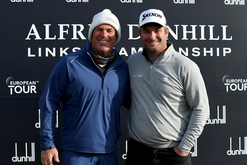 Former cricketer Shane Warne and New Zealand golfer Ryan Fox pose for a picture at the end of a golf tournament.
