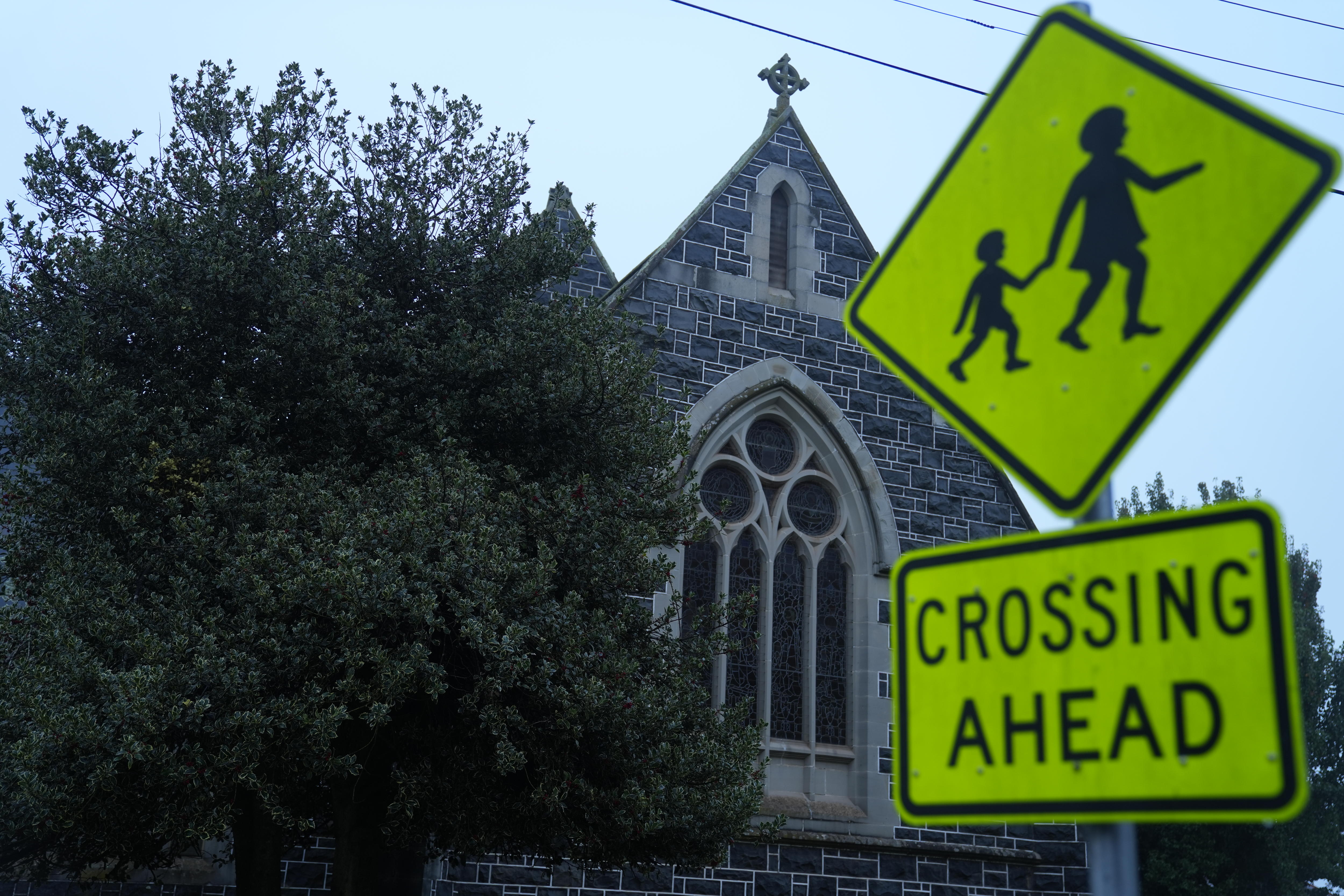 A 'crossing ahead' sign next to a church
