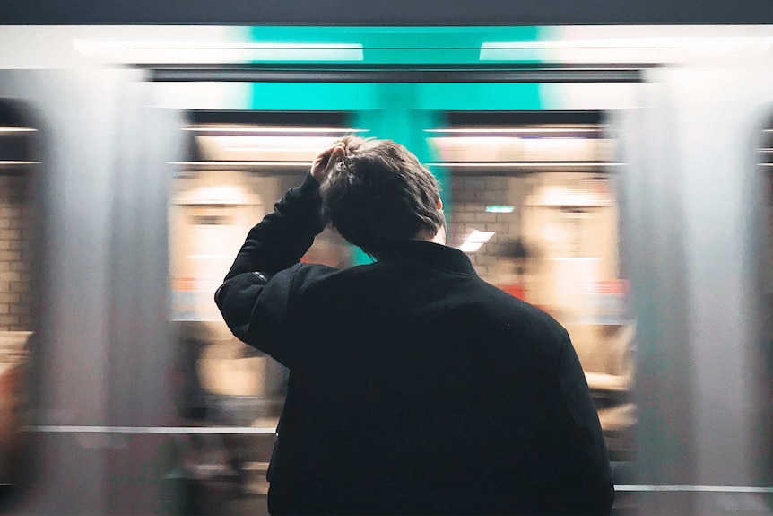 Man looking stressed while waiting for a train