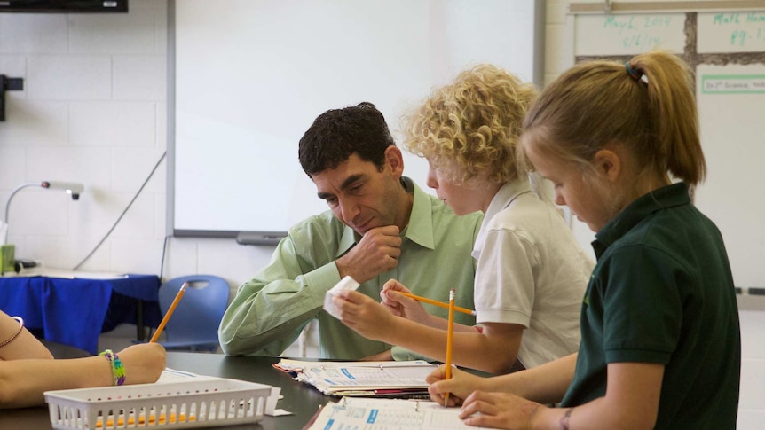 A teacher talks to students in a classroom.