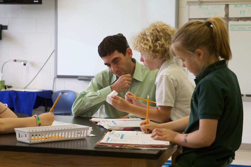 A teacher talks to students in a classroom.