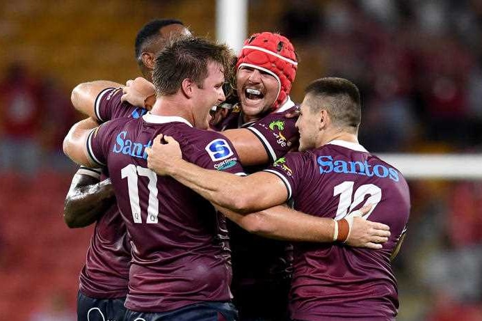 A group of footballers hugging in celebration.