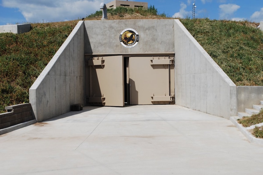 The above-ground entry point of concrete bunker with large concrete doors.