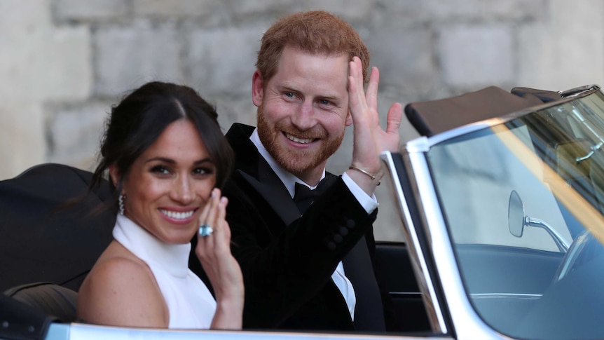 Harry and Meghan drive off in a silver jaguar