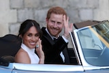 Harry and Meghan drive off in a silver jaguar