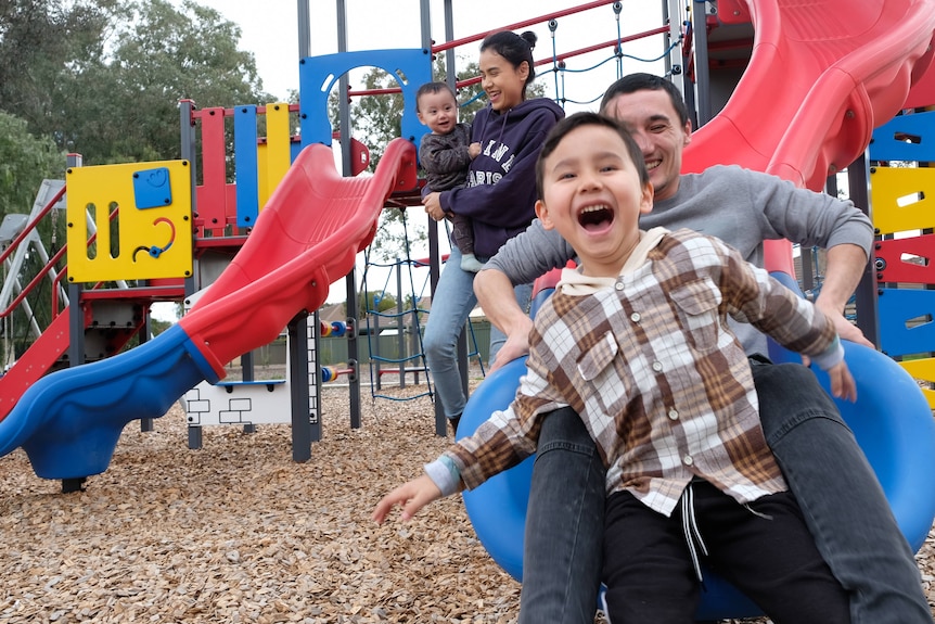 Family of four plays on slide