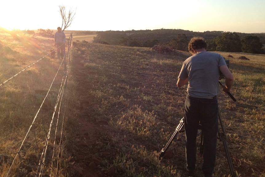 Australian Story cameraman Mark films farmer Stephen Marsh walking along property