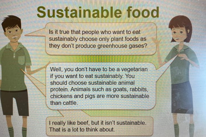 A photo of a PowerPoint slide that shows a conversation between a boy and a girl who is explaining sustainable meat
