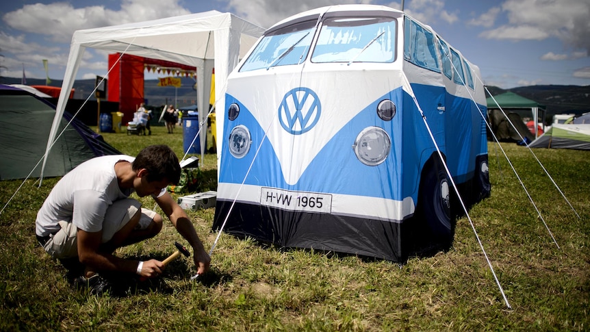 A festival-goer erects his combi van-shaped tent at the 37th Paleo Festival.