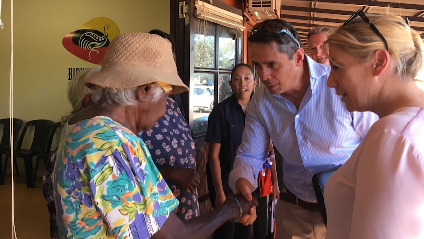Minister shakes the hand of an older Aboriginal lady