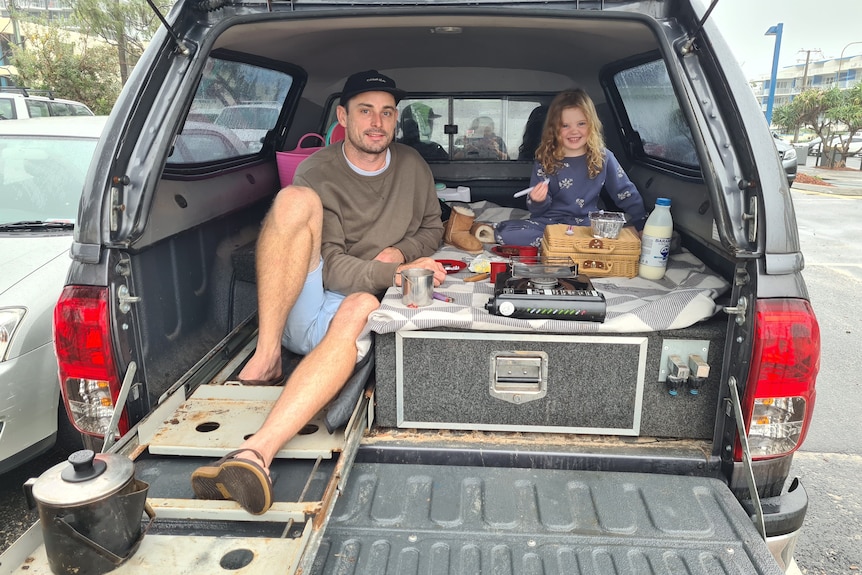 Cameron Brown and daughter Stevie have a breakfast picnic in back of their car 