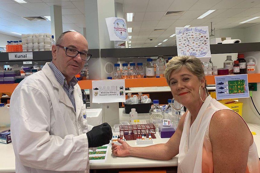 Professor Andreas Lopata with Paula Rodger in a clinic with her arm on a desk for a skin prick test.