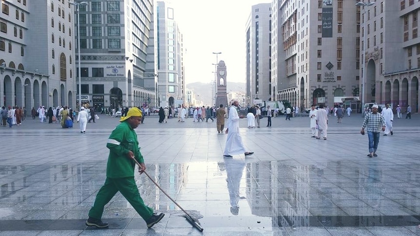 A man clean the lawn of the grand mosque in Madinah
