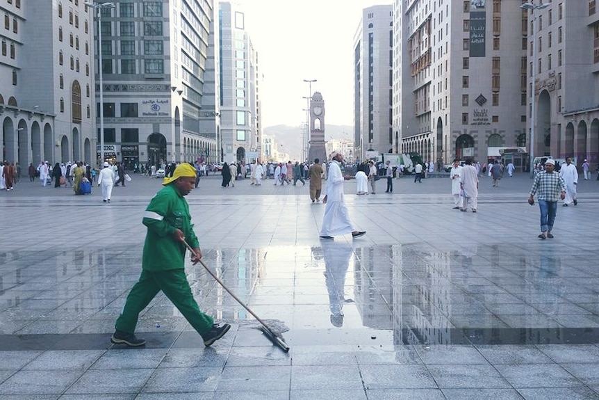 A man clean the lawn of the grand mosque in Madinah