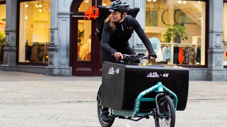 A cyclist in Netherlands delivers H&M clothing products to customers.