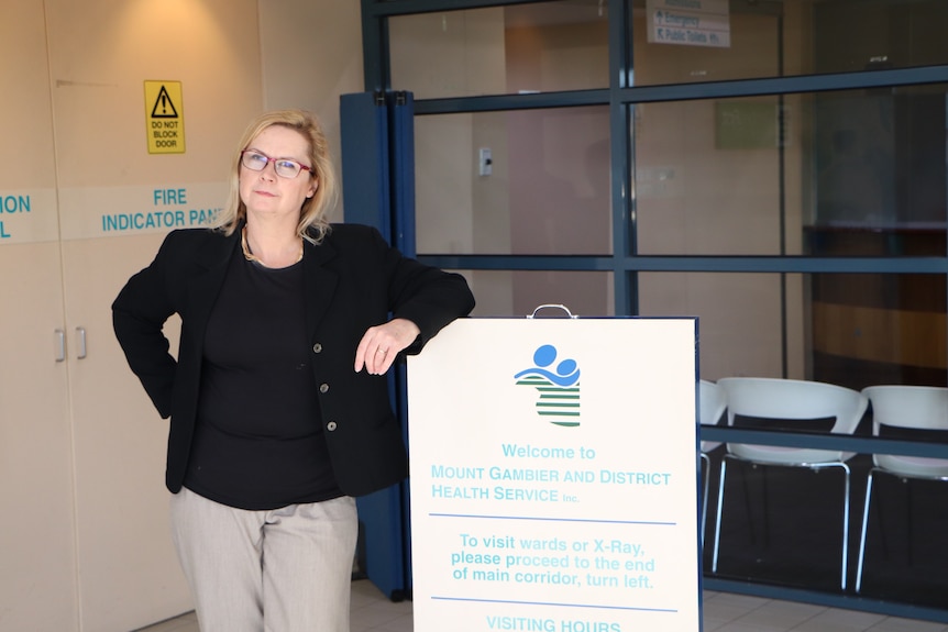 Woman stands outside of hospital