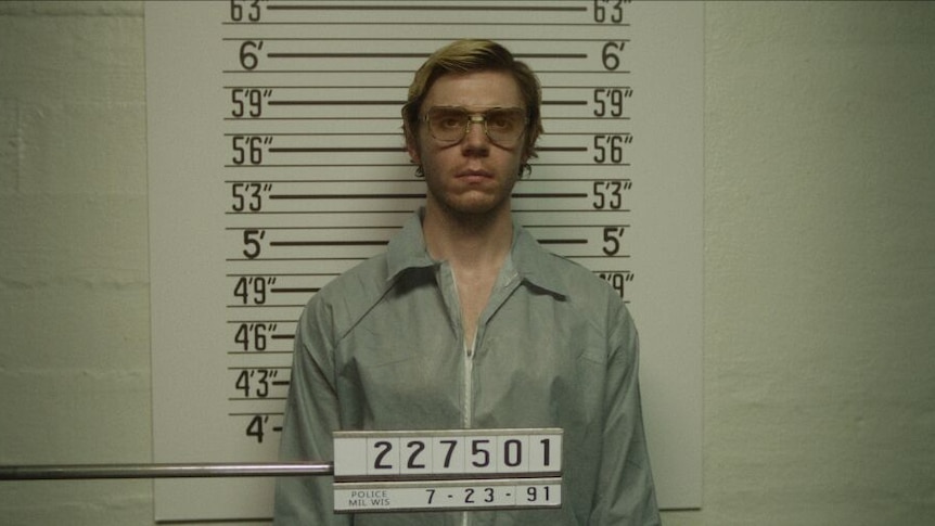 An image of a scene in the Netflix series about Jeffrey Dahmer, showing him having his photo taken in jail