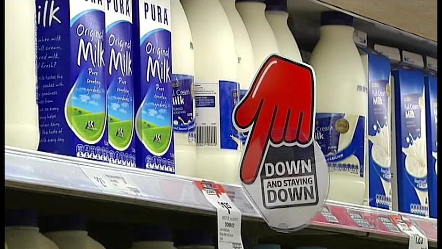 Fridge of milk with a red hand pointing down for discounted Coles supermarket milk.
