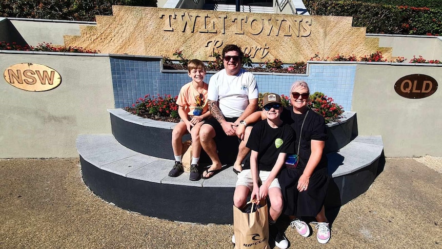 Family sitting on steps on the NSW and QLD broder