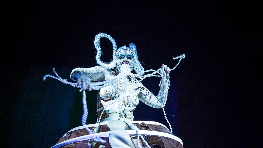 Colour photo of burlesque and performance artist Glitta Supernova performing on stage at Day for Night 2018.