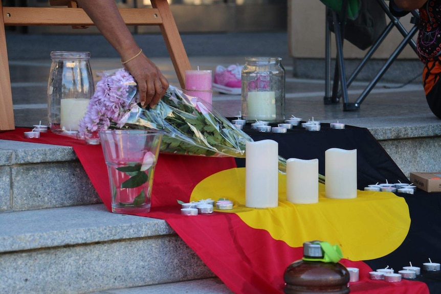 Flowers and candles at a vigil for Annaliesse Ugle.