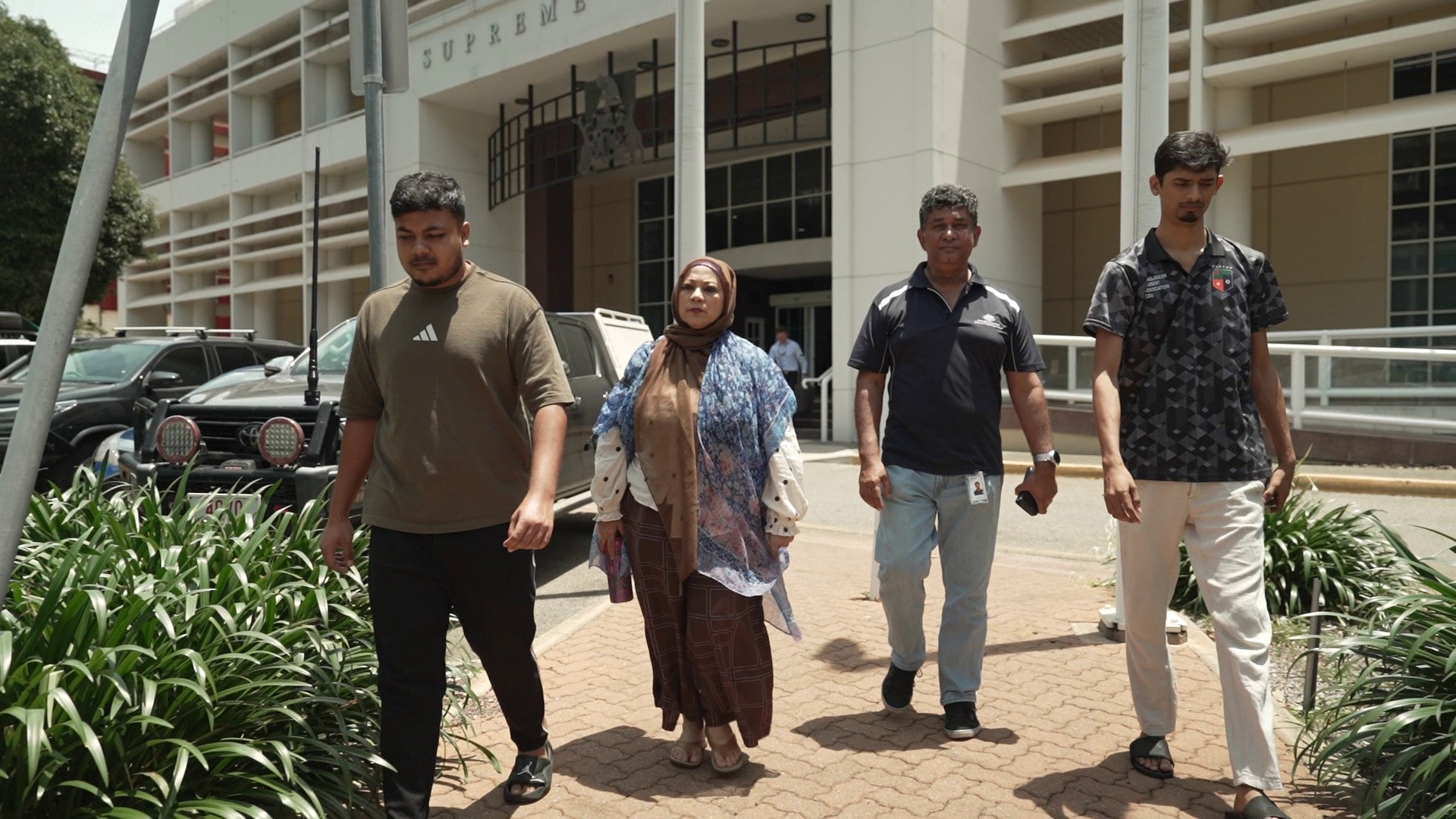 Three men and a woman leave court