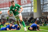 Garry Ringrose screams as he runs with the ball with three France players on the ground behind him
