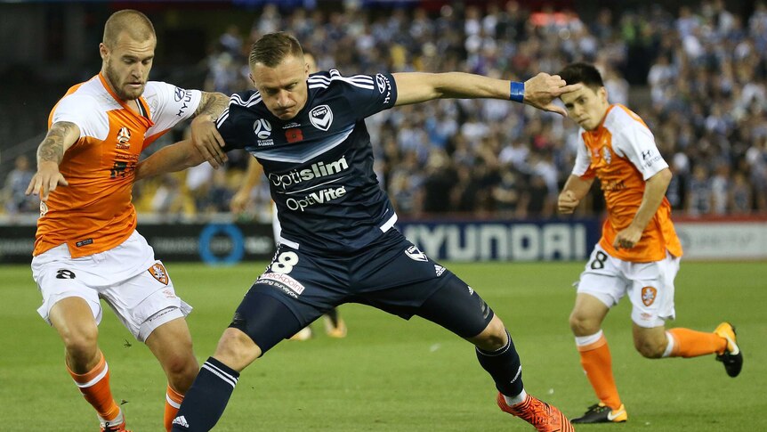 Victory spearhead Besart Berisha (R) tries to hold off the Roar's Jacob Pepper.