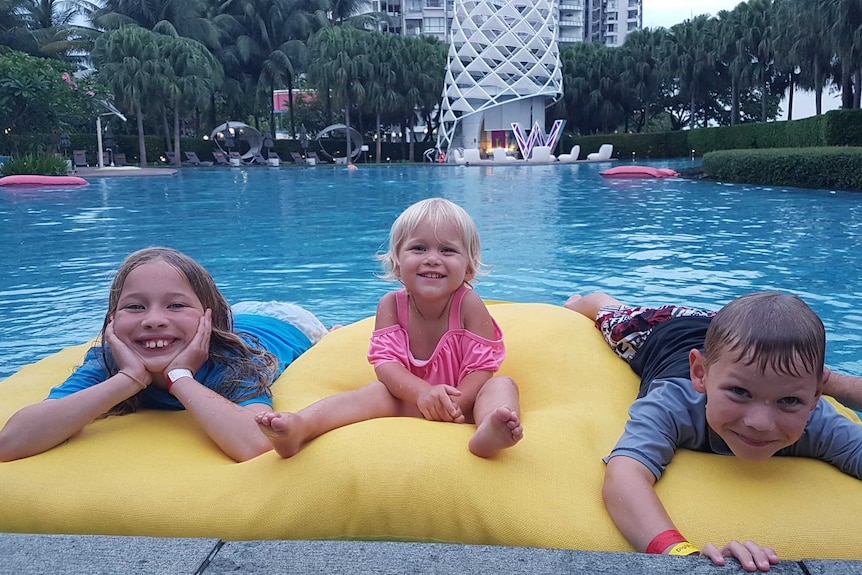 Three smiling young children in a swimming pool to depict getting the most out of summer holidays and leave.