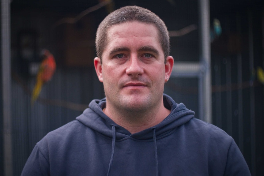 A man wearing a dark blue hoodie.