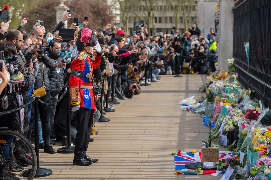 Mourners lay floral tributes outside Buckingham Palace following the announcement of the death of Prince Philip.