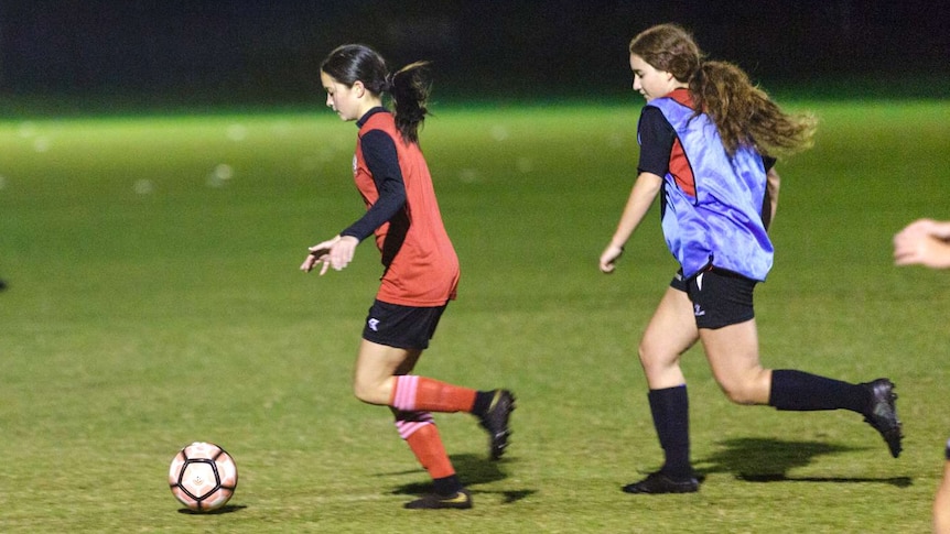 Northern Redbacks Women's Soccer Club under 16s captain Grace Monteiro runs with the ball ahead of a teammate at training.