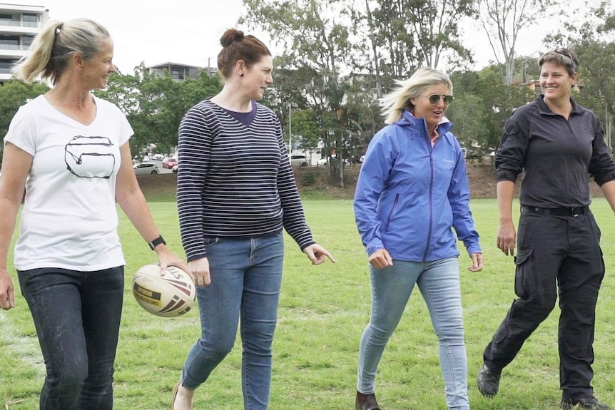 Tahnee Norris, Jo Barrett, Annie Banks & Heather Ballinger walking together on the field.