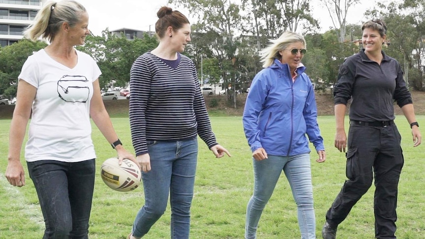 Tahnee Norris, Jo Barrett, Annie Banks & Heather Ballinger walking together on the field.