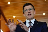 Alan Tudge stands in front of media in Canberra
