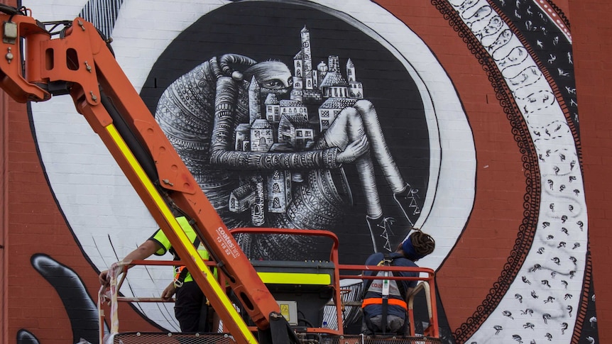 UK based artistic duo Phlegm work on a work on the wall of a Wellington Street Apartment block
