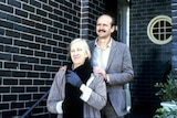 Garry McDonald as Arthur and Ruth Cracknell as Maggie standing in front of a house smiling, hands on shoulders.