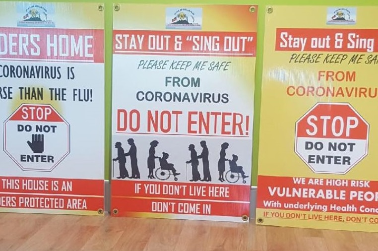 Three signs on front of some homes of vulnerable Palm Islanders during the coronavirus pandemic