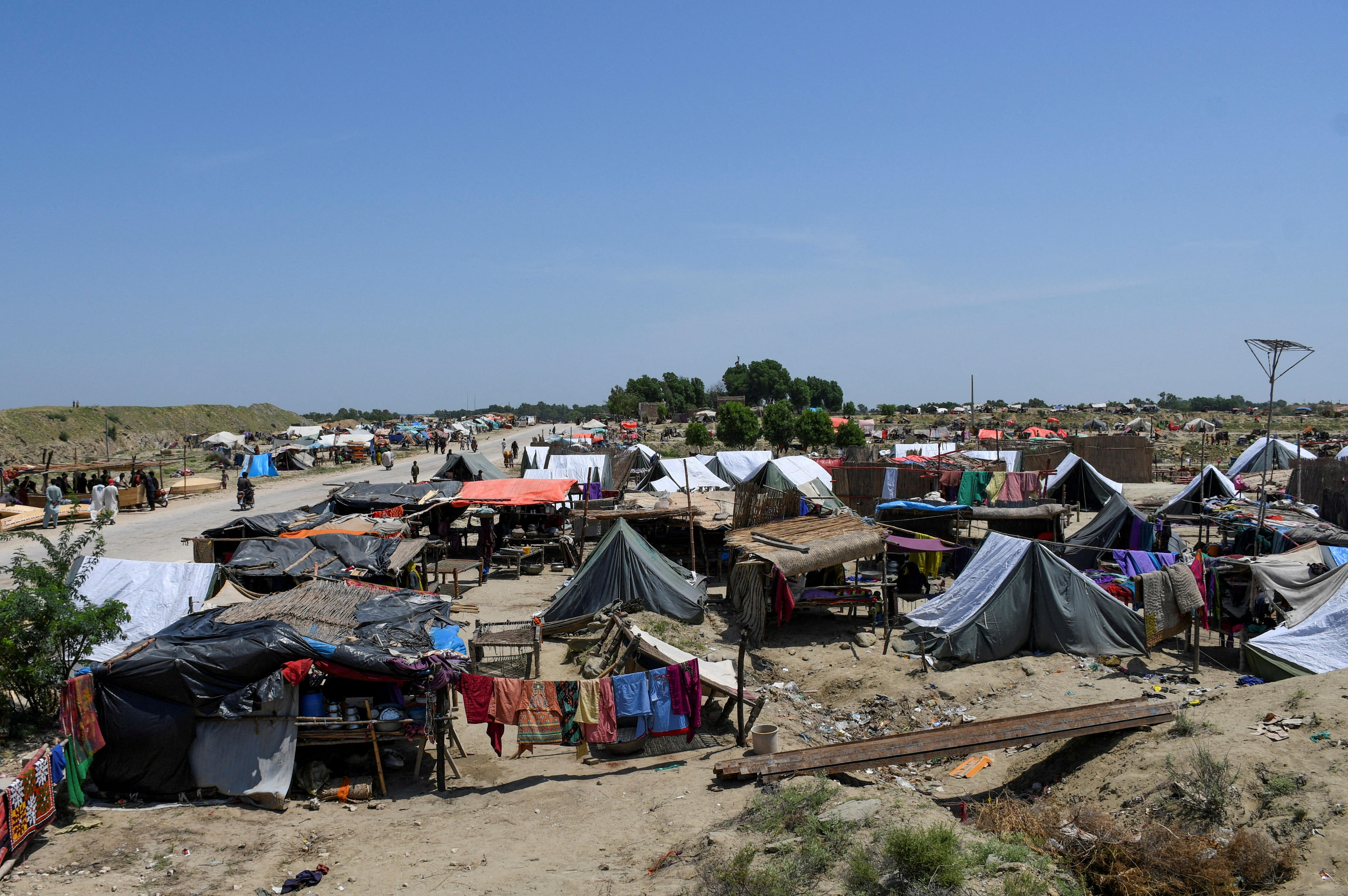 tents line the side of a dusty road. 