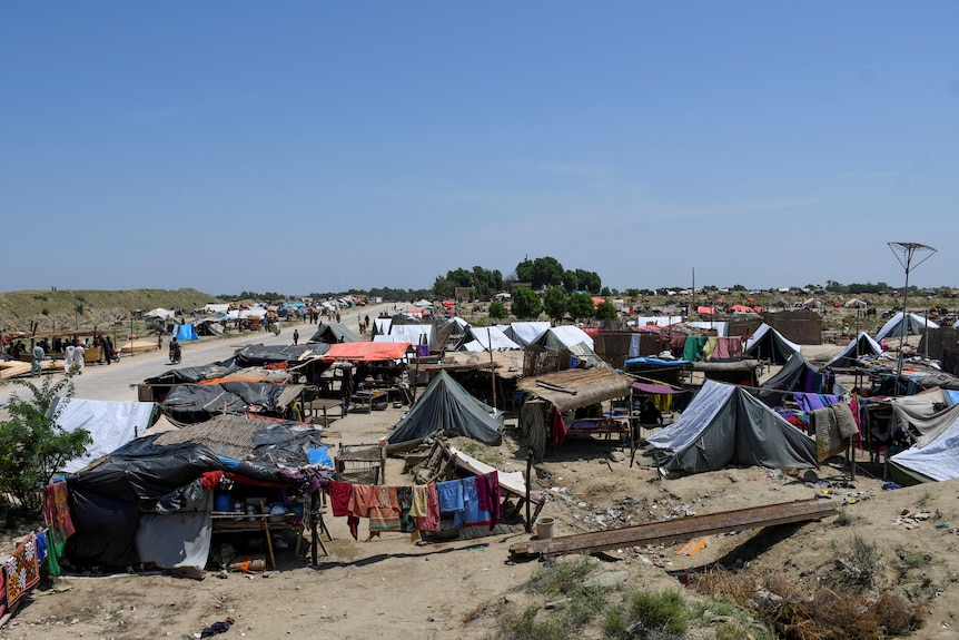 tents line the side of a dusty road. 