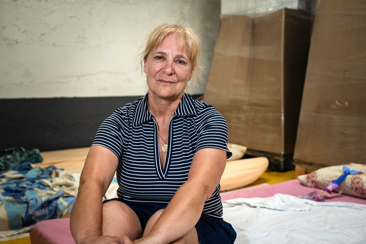 A woman sitting on the ground and looking at the camera.
