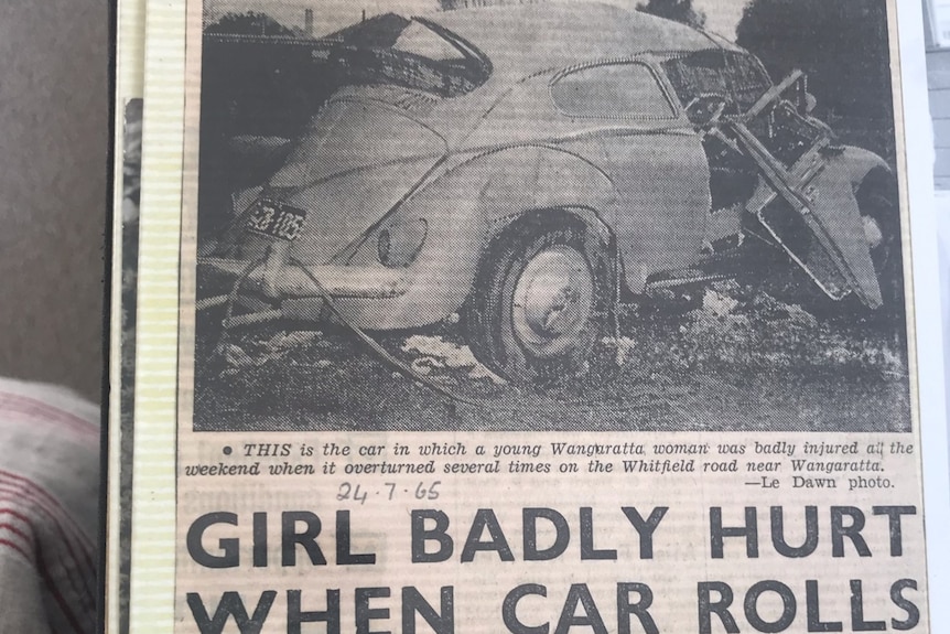 A photo of an old newspaper clipping with a photo of a badly mangled car and headline girl badly hurt