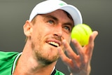 John Millman looks intently as he tosses the ball up to serve