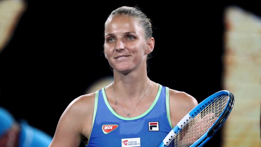 Karolina Pliskova applauds with her racket after winning a match at the Australian Open.