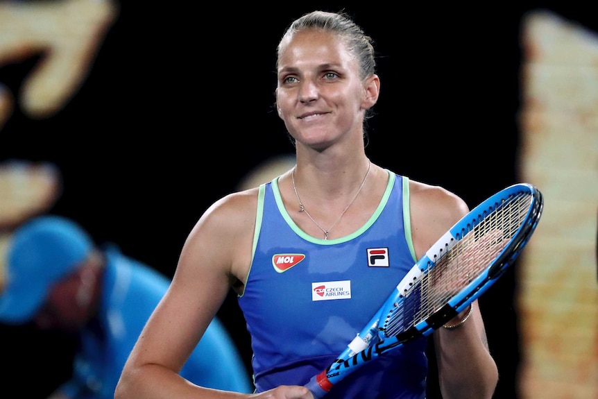 Karolina Pliskova applauds with her racket after winning a match at the Australian Open.