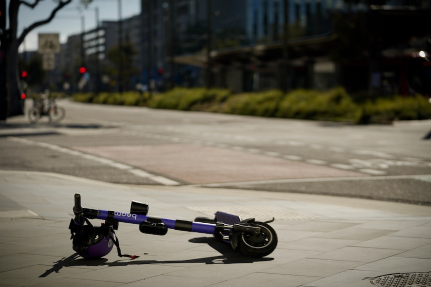 A fallen purple e-scooter lies in Canberra's CBD