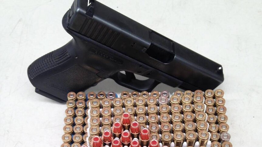 A close-up photo of a pistol and ammunition.