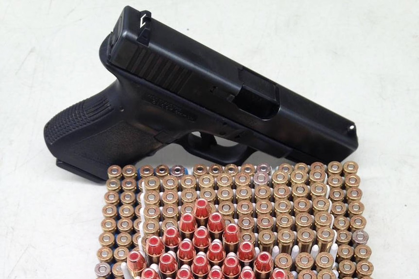 A close-up photo of a pistol and ammunition.