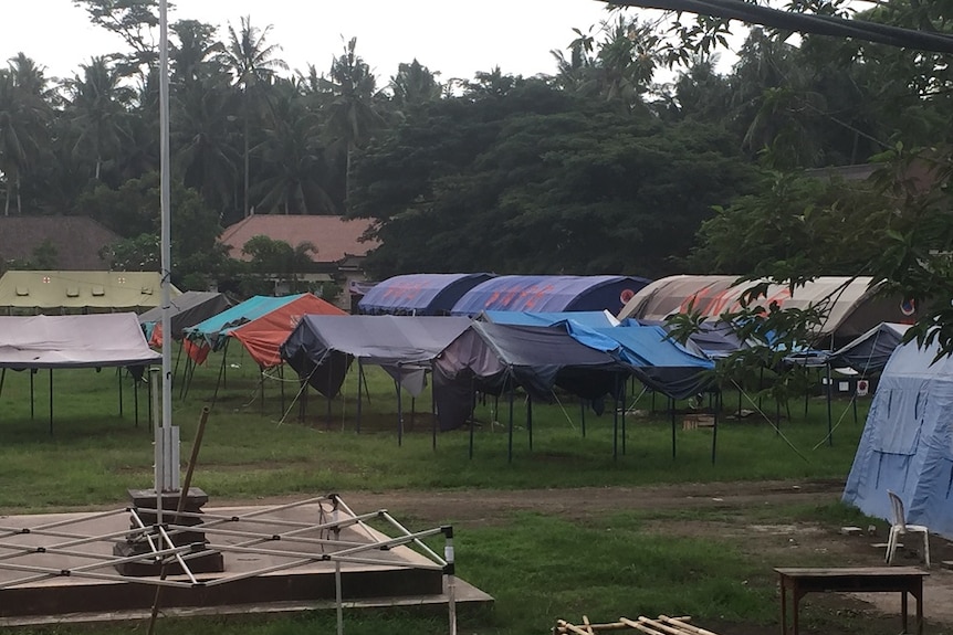 A line of empty tents in a field.