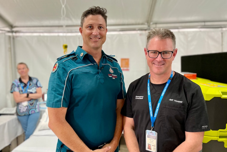 a paramedic and a doctor standing together in a medical tent